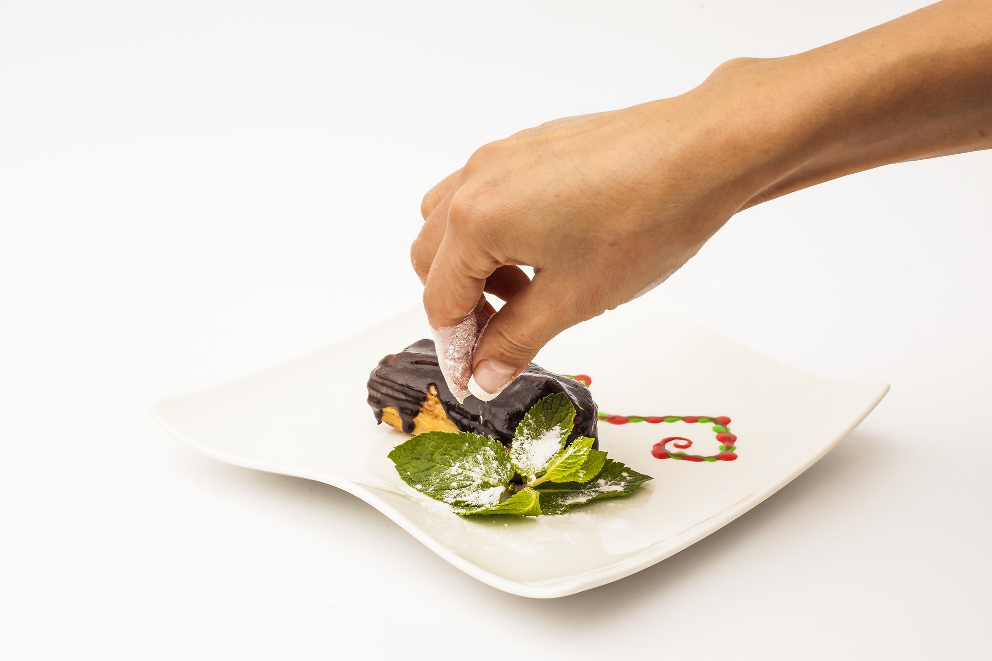 Close-up of hands plating garnish